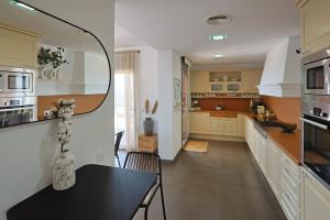 a kitchen with a table and a dining room at Villa Aya Barca in Santa Susanna