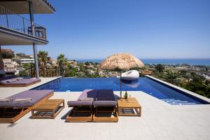 a villa with a swimming pool with chairs and an umbrella at Villa Aya Barca in Santa Susanna