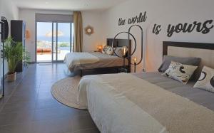 a bedroom with two beds and a sign that reads the world is yours at Villa Aya Barca in Santa Susanna +35 photos