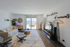 a living room with a couch and a tv at Villa Aya Barca in Santa Susanna