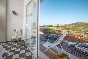a balcony with a chair and a view of the ocean at Lu Gamasinu di Ziu Vittorio in Santa Teresa Gallura