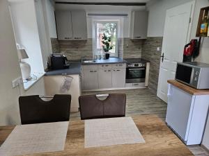 Una cocina con una mesa con sillas y un microondas. en Schmiedehaus, en Sahms