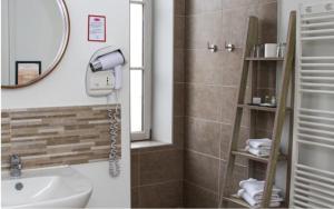 a bathroom with a sink and a mirror and a shower at La Maison de Mathilde in Bayeux