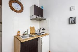 a small kitchen with a sink and a mirror at ANJ Appartement Centre Ville in Deauville +4 photos