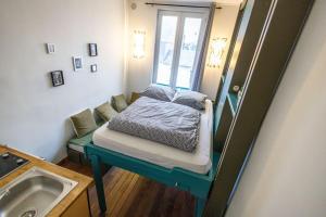 a small room with a bed and a sink at ANJ Appartement Centre Ville in Deauville