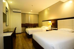 um quarto de hotel com duas camas e uma televisão em Ever O Business Hotel em Zamboanga