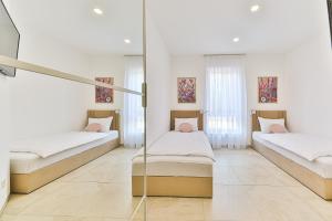 two beds in a room with white walls at Villa Pavlina in Kaštela +42 photos