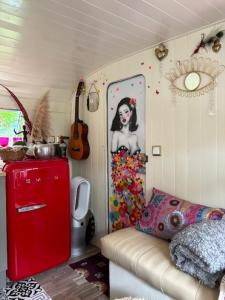 a living room with a red refrigerator and a couch at La Caraval in Saint-Pierre-des-Corps