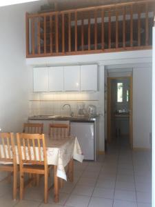 eine Küche mit einem Tisch und Stühlen sowie eine Küche mit weißen Schränken in der Unterkunft Village Club Dunea in Soustons