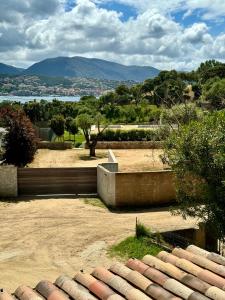 a view of a park with a lake and mountains at Appartement à 2 pas de la plage in Olmeto