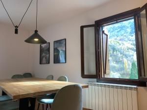 a dining room with a wooden table and a window at Villa Hoz de Jaca in Hoz de Jaca