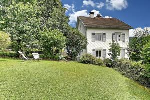 ein Haus mit einem Garten mit zwei Stühlen davor in der Unterkunft Le Cocoon Clairefontaine - Maison vue montagne in Cornimont