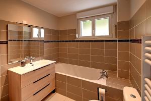 ein Badezimmer mit Badewanne und Waschbecken in der Unterkunft Le Cocoon Clairefontaine - Maison vue montagne in Cornimont