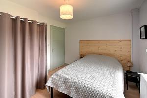 ein Schlafzimmer mit einem Bett in einem Zimmer mit einem Vorhang in der Unterkunft Le Cocoon Clairefontaine - Maison vue montagne in Cornimont