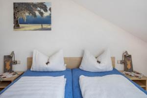 two beds in a room with blue sheets and white pillows at Sport Rees - Ferienwohnung Pia in Hofsgrund
