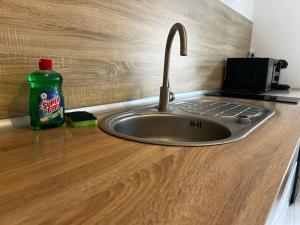 a kitchen counter with a sink and a bottle of cleaner at Grand appartement avec jardin - Centre ville in Cambrai