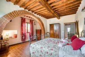 a bedroom with a large bed with an archway at Le Spighe - Charming Apt with Communal Pool in Piana +18 photos