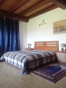 a bedroom with a bed with blue curtains and a rug at Silentium Domus doo in Gornje Vreme