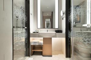 a bathroom with a sink and a mirror at 东莞大朗希尔顿欢朋酒店 in Huangcaolang
