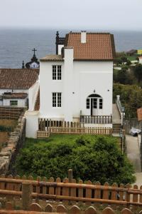 a white house with the ocean in the background at Casa do Vale do Sossego in Capelas