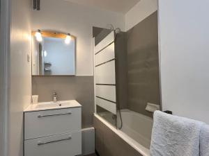 een badkamer met een wastafel, een bad en een spiegel bij Harmonie - Affaires & Loisirs à Rueil in Rueil-Malmaison