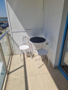 a small table and two chairs on a balcony at Garsoniera 23 august in Douăzeci şi Trei August +2 photos