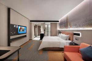 a hotel room with a bed and a tv at 东莞大朗希尔顿欢朋酒店 in Huangcaolang