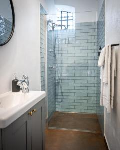ein Badezimmer mit Waschbecken und Dusche in der Unterkunft Gamle Fengselet Kulturhotell in Stord