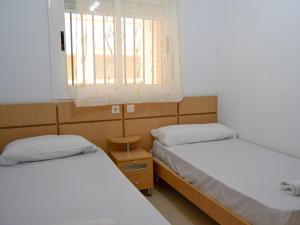 two beds in a small room with a window at Apartamentos 3000 Marina D'Or in Oropesa del Mar +125 photos