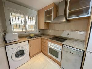 a kitchen with a washing machine and a washer at Apartamentos 3000 Marina D'Or in Oropesa del Mar