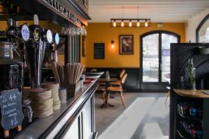 a bar in a restaurant with a table and chairs at La Maison de Mathilde in Bayeux