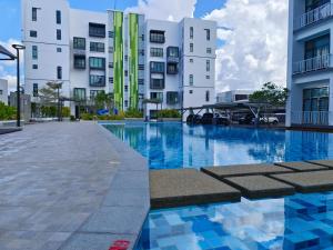 a swimming pool in front of some buildings at Jk CozyStay 10Pax 300Mbps 3BedR 2BathR 2ShadedCarpark in Kuching
