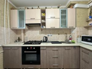 Una cocina con gabinetes de madera y un horno de estufa. en Modern Apartment - Calm Location - Boat in the Yard, en Chişinău
