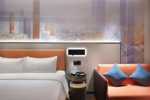 a hotel room with two beds and a chair at 东莞大朗希尔顿欢朋酒店 in Huangcaolang