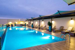 a large swimming pool with chairs and umbrellas at Hilton Garden Inn Nairobi Airport in Nairobi