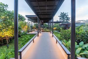 a walkway in the middle of a garden at Chatrium Golf Resort Soi Dao Chanthaburi in Ban Thap Sai