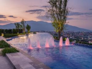 a water fountain with a city in the background at Astra Sky River Chang Khlan Chiang Mai in Chiang Mai