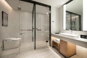 a bathroom with a shower and a sink at 东莞大朗希尔顿欢朋酒店 in Huangcaolang