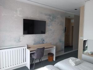 a bedroom with a desk and a tv on a wall at Przystań Powiat Nakielski in Nakło nad Notecią