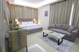 a bedroom with a bed and a couch and a table at Palm Boutique Suites Hotel in Beirut