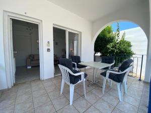 a room with a table and chairs on a balcony at Polis Chrysochous Entire Apartment in Polis Chrysochous