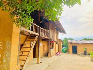 a building with a staircase on the side of it at Dồn Dao Homestay in Ha Giang