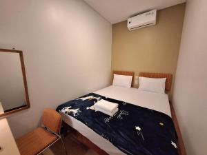 雅加达Senayan Stay的一间卧室配有一张带蓝色毯子和鲜花的床