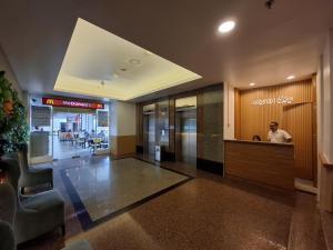 a lobby of a building with a man sitting at a counter at Senayan Stay in Jakarta