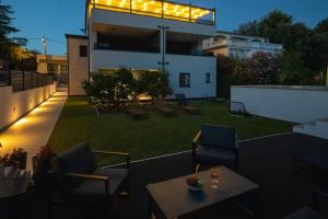 a patio with chairs and a table on a building at Apartmani Ante & Ivano Biograd with POOL in Biograd na Moru