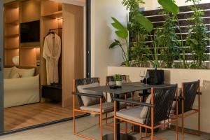 a dining room with a table and chairs with plants at Evanik Chic Hotel in Kalymnos