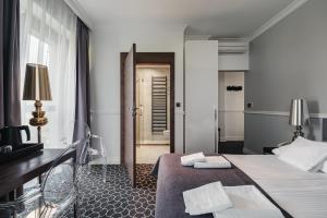 a hotel room with a bed and a desk and a door at Rewita Imperial in Sopot