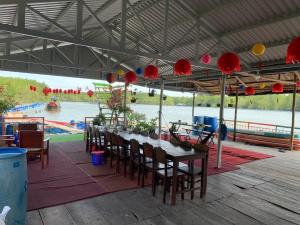 a long table with chairs and red paper lanterns at Cần Giờ Floating House in Ấp Phước Thới