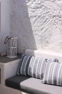 a bench with two pillows on it next to a wall at Anastasia Kimolos in Kimolos +4 photos