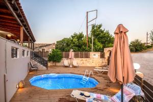 a patio with an umbrella and a swimming pool at Amalia Villa with Private Pool in Perama